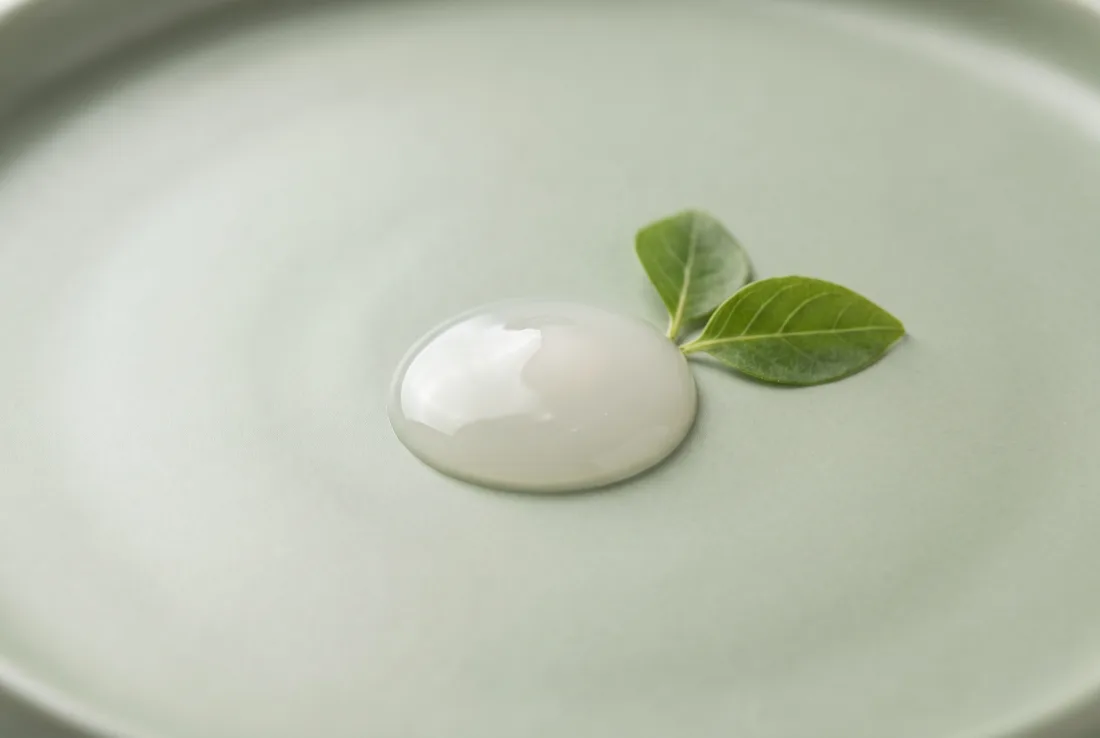 The light, silky texture of the serum on a soft background